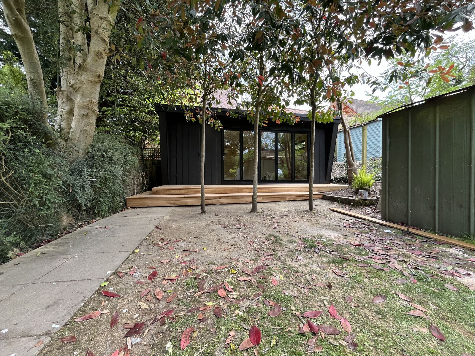 Completed black-clad garden room with bi-fold doors and hardwood deck